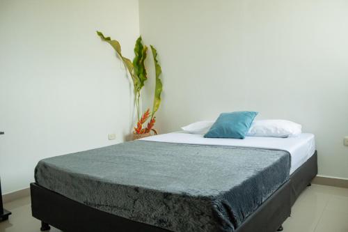 a bed with a blue pillow on top of it at apartamento con alma 888 in Coveñitas