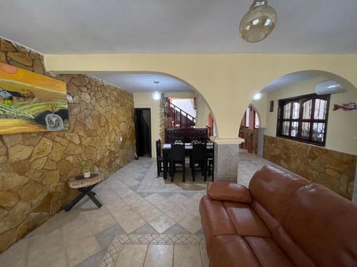 a living room with a couch and a stone wall at La casa de la abuela in Palenque