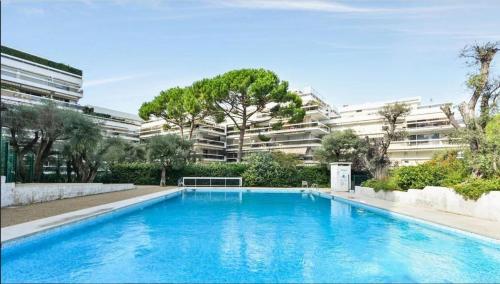 une grande piscine bleue devant un immeuble dans l'établissement Studio Mer Sérénité, à Antibes
