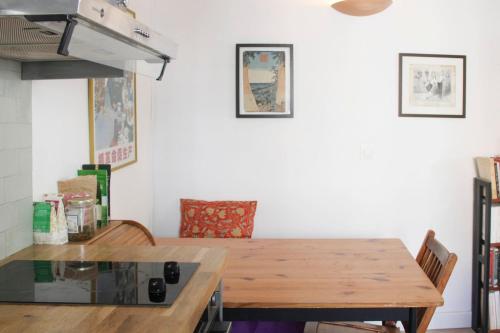 une cuisine avec une table en bois et quelques chaises dans l'établissement Beautiful studio for couple with courtyard, à Paris