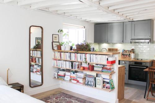une chambre avec des étagères remplies de livres dans l'établissement Beautiful studio for couple with courtyard, à Paris