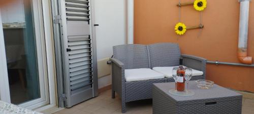 una silla de mimbre sentada en un balcón con una mesa en La casa di Steno, en Lecce