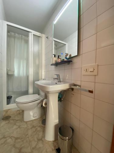 a bathroom with a sink and a toilet and a mirror at Brisa y Mar in Punta Umbría