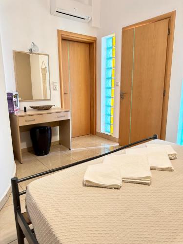 a bedroom with a bed and a sink and a mirror at Pachia Ammos Falasarna in Falasarna
