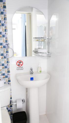 a white bathroom with a sink and a toilet at Coconut Beach lodge #1 in San Andrés