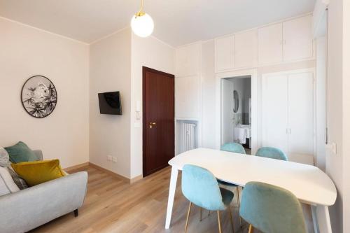 sala de estar con mesa blanca y sillas azules en Sweet Green Apt Tortona District, en Milán
