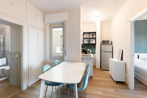 Una cocina y un comedor con una mesa y sillas blancas. en Sweet Green Apt Tortona District, en Milán