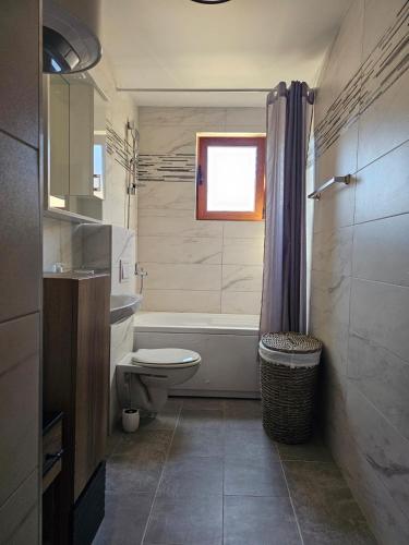 a bathroom with a tub and a toilet and a sink at Adria Montenegro Apartment in Tušupi