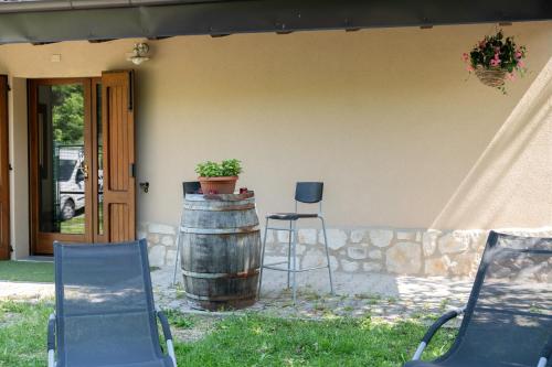 a house with a barrel and a chair and a plant at Casa Il Nocciolo in Rocca Malatina