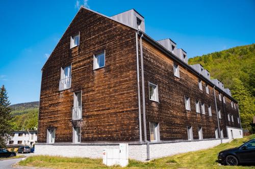 a large brown brick building with white windows at Apartmán na Divoké Desné in Andělské Žleby