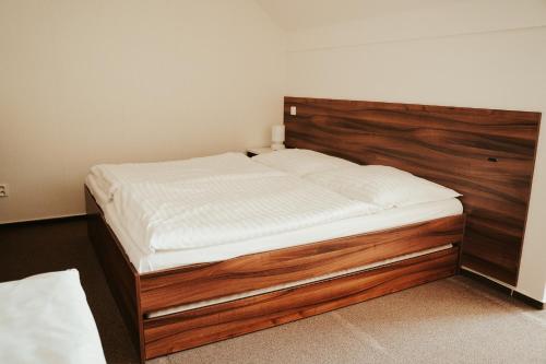 a bed with a wooden headboard in a room at Apartmán na Divoké Desné in Andělské Žleby