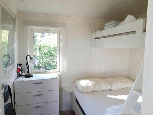 ein kleines Schlafzimmer mit einem Etagenbett und einem Fenster in der Unterkunft Sjarmerende liten gjestehytte in Fredrikstad