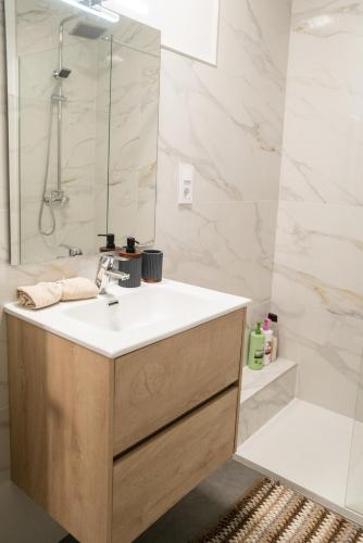 a bathroom with a sink and a shower at Bungalow - Playa Meloneras in San Bartolomé