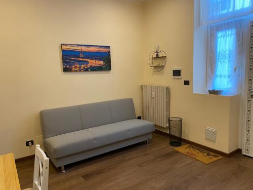 a living room with a couch and a picture on the wall at Appartamento piano terra con Idromassaggio Parco Dora-Daniele's House in Turin