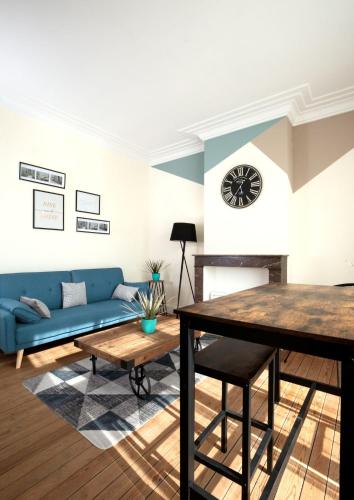 un salon avec un canapé bleu et une table dans l'établissement Résidence Cawikima - Willis Home, à Boulogne-sur-Mer