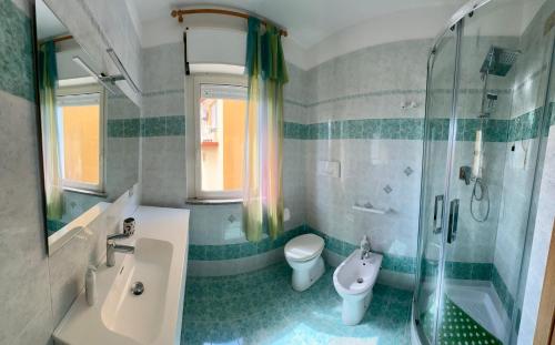 ein Badezimmer mit Waschbecken, Toilette und Dusche in der Unterkunft SPARGI Apartment in La Maddalena