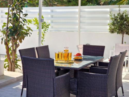 a table with chairs and drinks on a patio at Moments Together Villa in Voroklini