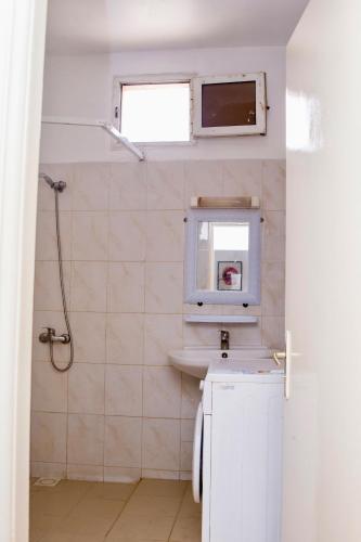 a bathroom with a sink and a toilet and a window at Studio meublé vue sur Mer in Dakar