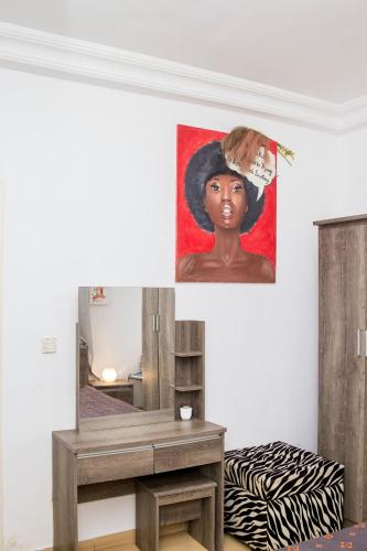 a painting of a black woman hanging on a wall at Studio meublé vue sur Mer in Dakar