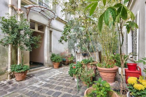 Une bande de plantes en pot assise dans une rue dans l'établissement Modern Renovated studio cozy and quiet, à Paris