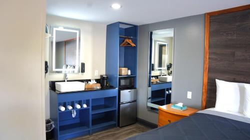 a bedroom with a sink and a blue wall at Carrier Motor Lodge in Newington