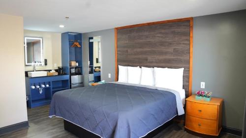a bedroom with a large bed with a wooden headboard at Carrier Motor Lodge in Newington