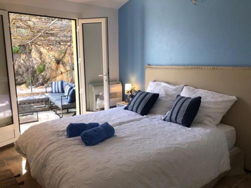 - une chambre avec un grand lit doté de 2 oreillers bleus dans l'établissement Villa la Roche Cannes, Meerblick, Salzwasserpool, Sauna, à Mandelieu-la-Napoule