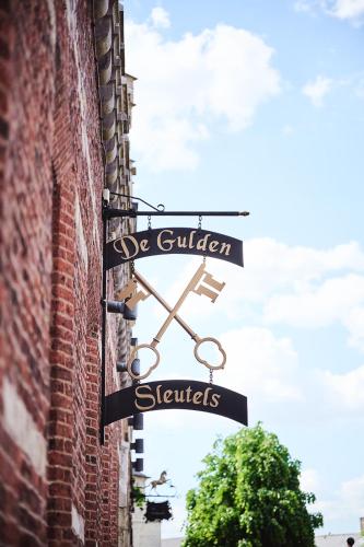 a street sign on the side of a brick building at Vakantiewoning De Gulden Sleutels in Kruibeke