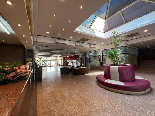 a lobby with a purple bench in a building at Ramada by Wyndham Princess Belize City in Belize City