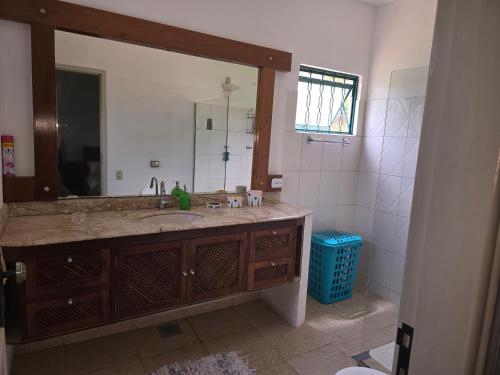 a bathroom with a sink and a large mirror at Casa de Fazenda Vale da Forquilha in Jacutinga