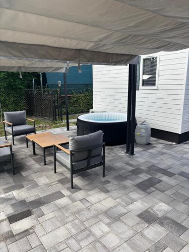 un patio con cama, mesa y sillas en A mi kis mobilházunk, en Pilismarót