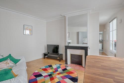 un salon avec un canapé et une cheminée dans l'établissement Cosy flat - Luxembourg Garden - Saint Germain des Prés, à Paris