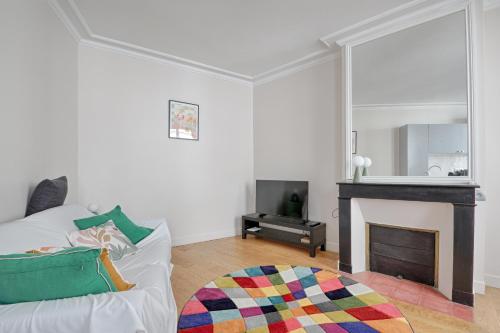 un salon avec un canapé blanc et une cheminée dans l'établissement Cosy flat - Luxembourg Garden - Saint Germain des Prés, à Paris