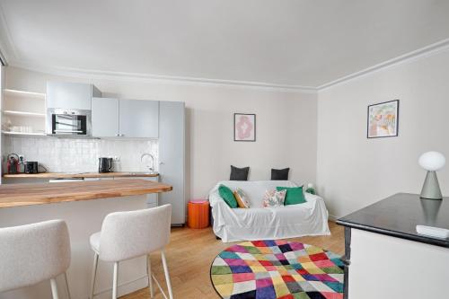 une cuisine et un salon avec un canapé dans l'établissement Cosy flat - Luxembourg Garden - Saint Germain des Prés, à Paris