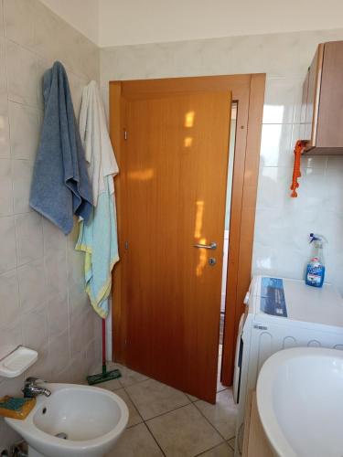 a bathroom with a toilet and a sink and a door at Appartamento Rosa in Savio di Ravenna