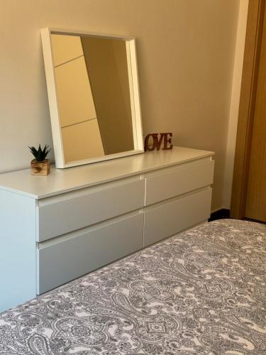 a bedroom with a dresser with a mirror at Ático in Pego