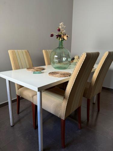 a table with a vase with flowers in it at Ático in Pego
