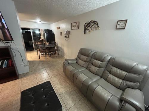 a living room with a leather couch and a table at The Sunshine State Midpoint in Seffner