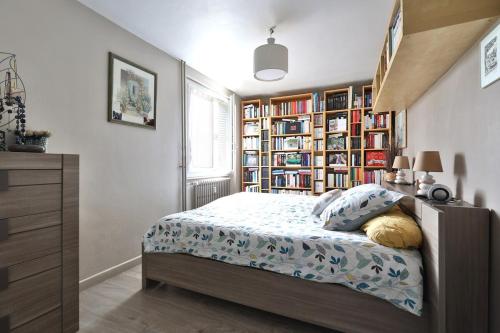 une chambre avec un lit et une étagère dans l'établissement Logement chaleureux avec balcon, à Bron