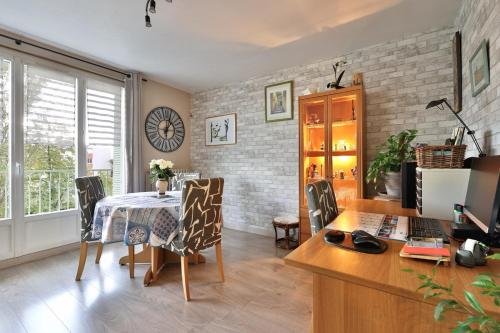 d'une salle à manger avec une table, des chaises et un bureau. dans l'établissement Logement chaleureux avec balcon, à Bron
