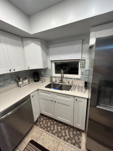 a kitchen with white cabinets and a sink at The Sunshine State Midpoint in Seffner