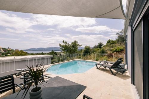 a swimming pool on a balcony with a chair at Cranae Tranquil Luxury Villas in Gythio