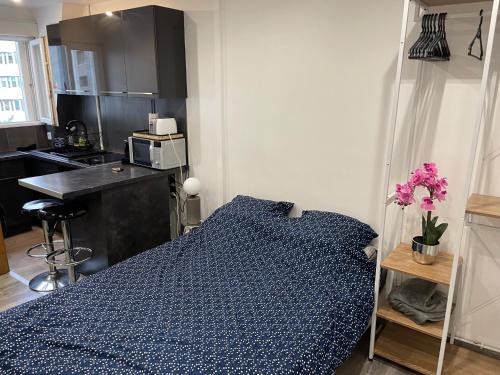 une chambre avec un lit bleu dans une cuisine dans l'établissement studio Champs Elysees, à Paris