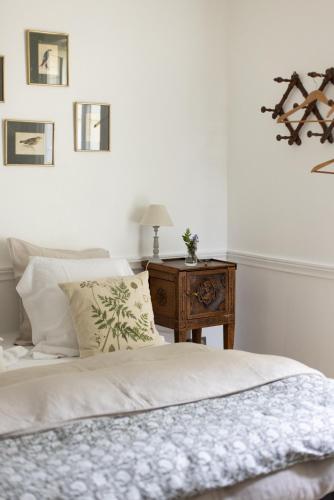 une chambre avec un lit et une table avec une lampe dans l'établissement Le Manoir du Plessis, à Dancé