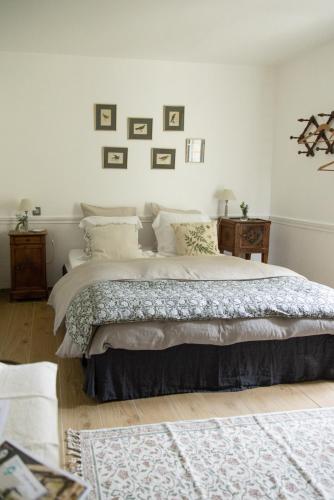 - une chambre avec un grand lit aux murs blancs dans l'établissement Le Manoir du Plessis, à Dancé