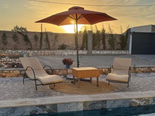 2 chaises et une table avec un parasol dans l'établissement Sweety Mogador, à Essaouira