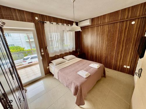 a bedroom with a bed and a large window at Sea House in Hanioti