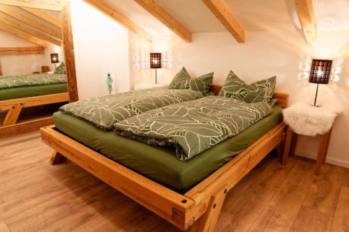 a bedroom with a bed with a green comforter at Lord Michael Chalet in Bodenmais