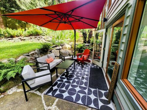 un patio avec un parasol rouge sur une maison dans l'établissement 2BD Guest Suite Sleeps 6 Near Downtown & Beach, à West Vancouver
