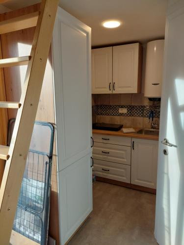 a kitchen with white cabinets and a staircase at Istrian Experience in Sočerga
